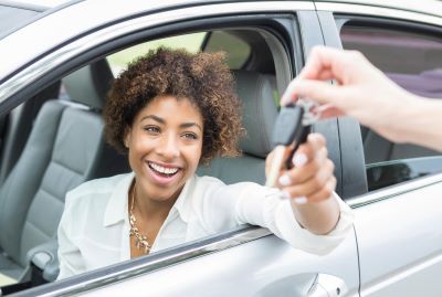 Excited young woman accepts new car keys